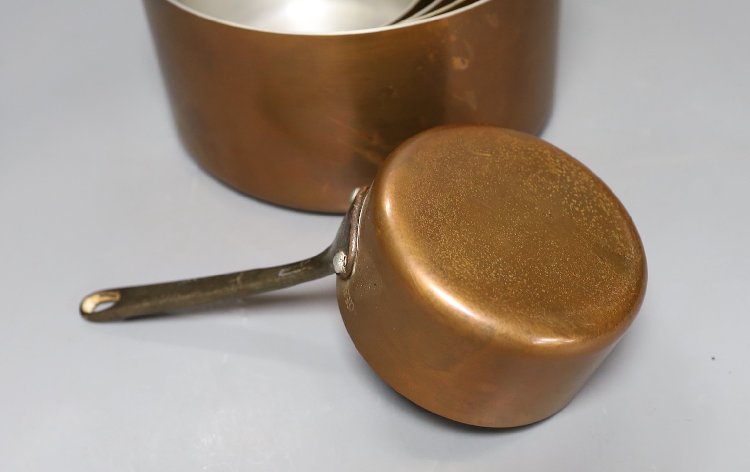 A set of 5 French graduated copper pans